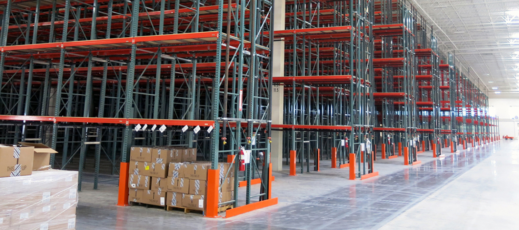 Angled view of several rows of newly installed pallet rack aisles in a Central Ohio retailer warehouse.