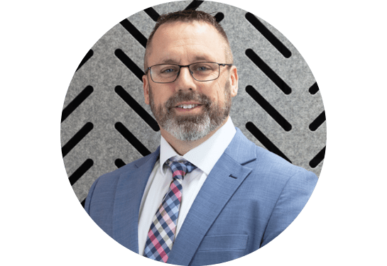 Profile picture of Scott Schloss, RSC Director, National Accounts. In a blue suit with plaid tie on gray patterned background.