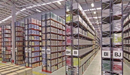 Multiple aisles of warehouse rack full of pallet cartons.