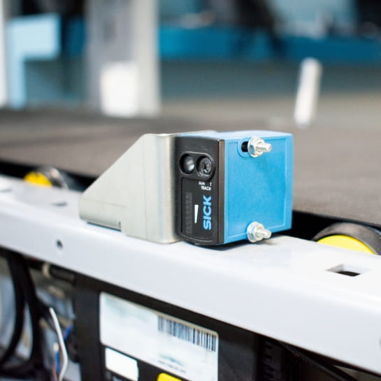 Close up of a Sick motion sensor attached to a conveyor system.