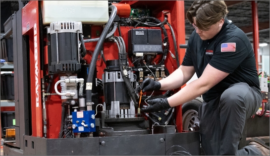 Raymond Storage Concepts technician checking the oil of a forklift. Forklift cover off exposing the engine.