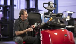 RSC technician sitting next to Raymond forklift checking the battery voltage with meter.
