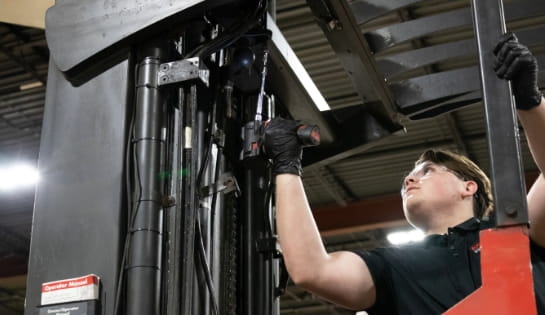 RSC shop technician using an electric drill to secure the overhead protection on a used forklift.