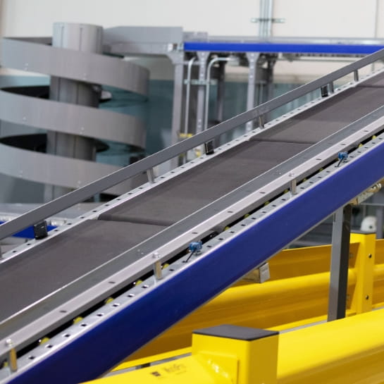 Conveyor ramp angled upward with conveyor screw in the background.