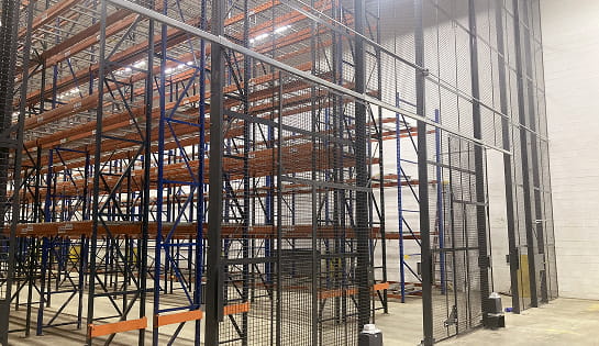 Wire security cage surrounding warehouse racking.