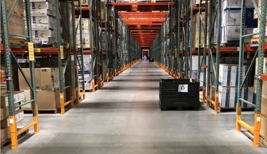 View through rack aisle pass throughs. Racking in full of pallets. Racking are paired guards and labels.
