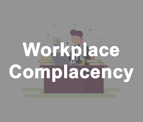 Workplace Complacency. Person working at his desk with books and laptop.